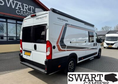 White Weinsberg camper van with orange/gray graphics parked outside a Swart Campers showroom. The back doors are visible with a Dutch license plate.