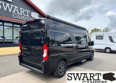 Black Knaus Box Life camper van parked outside a Swart Campers showroom, with another white motorhome in the lot nearby.