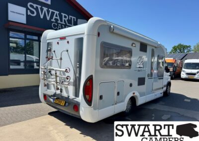 White Sun Ti camper van with a bike rack on the rear, parked outside Swart Campers.