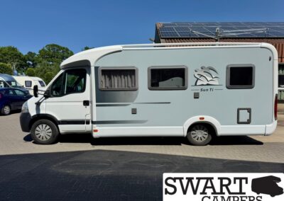 White motorhome with Sun Ti logo parked in a lot, solar panels on the roof and tinted windows. Visible SWART CAMPERS logo overlay on bottom corner.