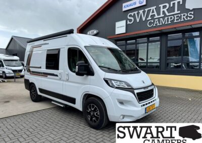 White camper van parked outside a Swart Campers building with large signage. Dutch license plate visible (GS-70-?).