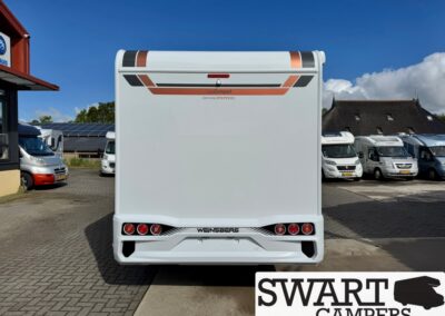 Rear view of a white Weinsberg caravan with red tail lights, parked among motorhomes at a dealership; SWART CAMPERS watermark in corner.