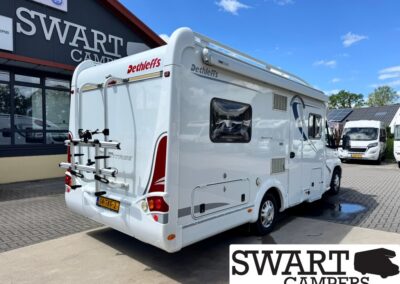 White Dethleffs motorhome with rear bike rack parked outside a dealership; Swart Campers sign visible in the background.