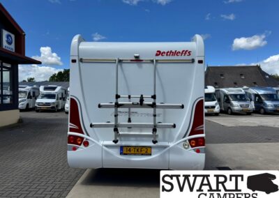 Rear view of a white Dethleffs caravan with a bike rack on its back, parked in a camper lot; Swart Campers watermark visible.