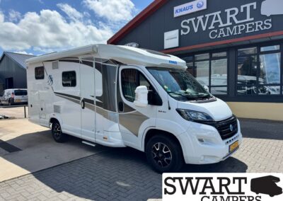 White motorhome parked outside a camper shop with a large SWART CAMPERS sign in the background. Readable KNAUS logo on the vehicle roof.