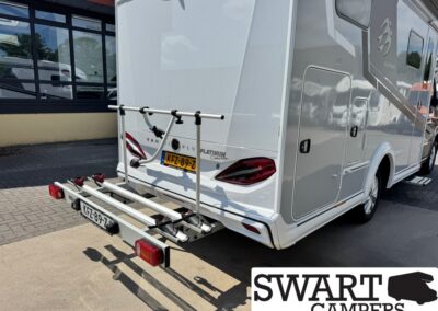 White motorhome with a mounted rear bike rack on a paved surface, SWART CAMPERS logo visible in the corner.
