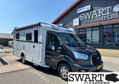 White and black motorhome parked outside a Swart Campers showroom with a large 'SWART CAMPERS' sign above and a Ford front cab.