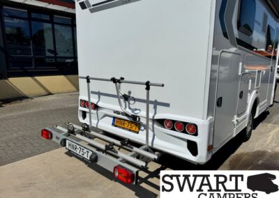 Rear view of a white camper with a bicycle rack mounted on the back, license plate HNR-75-T, and SWART CAMPERS logo in the corner.
