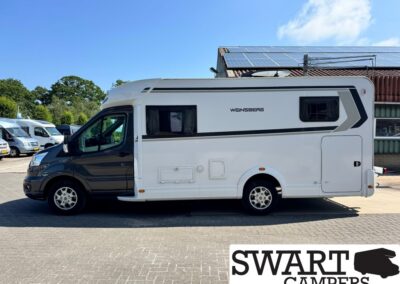 Side view of a white Weinsberg camper van with a black stripe and roof solar panels on a sunny day