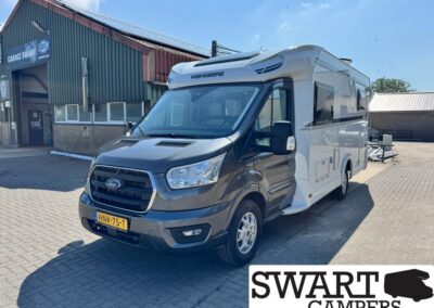 Front three-quarter view of a Ford-based Weinsberg motorhome parked outside a workshop.