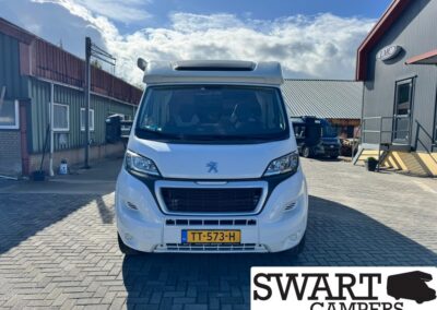 Front view of a white camper van with Dutch license plate TT-573-H parked in a brick-paved lot; SWART CAMPERS logo visible in bottom-right corner.