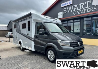 Grey and black Knaus motorhome parked outside the Swart Campers dealership, front VW badge visible on the cab.