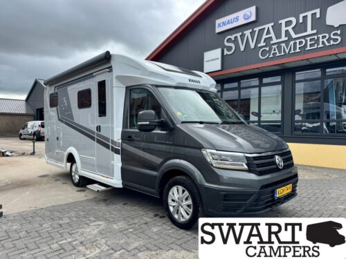 Grey and black Knaus motorhome parked outside the Swart Campers dealership, front VW badge visible on the cab.
