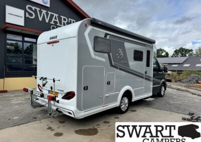 Grey and white Knaus camper van parked outside Swart Campers showroom, rear bike rack attached.