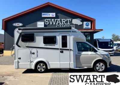 White motorhome on display in front of a Swart Campers showroom with KNAUS logos above.