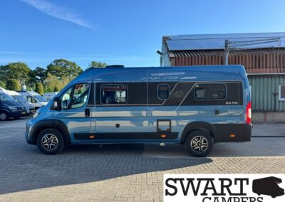 Blue high-roof camper van parked on a paved lot, with silver and dark graphics along its side and 'BOX TIME' text toward the rear. SWART CAMPERS watermark in bottom corner.