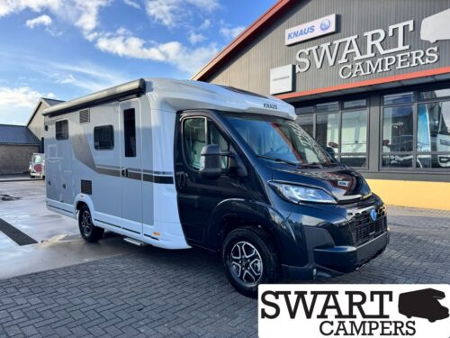 KNAUS LVE TI 650 MEG PLATINUM SELECTION - Swart Campers Black and white motorhome parked outside Swart Campers dealership, with a large SWART CAMPERS sign in the background and a blue sky above.