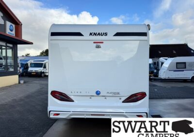 Rear view of a white KNAUS caravan on a dealership lot, with other caravans in the background.