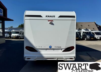 Rear view of a white Knaus caravan with Platinum Edition badge in a camper lot.