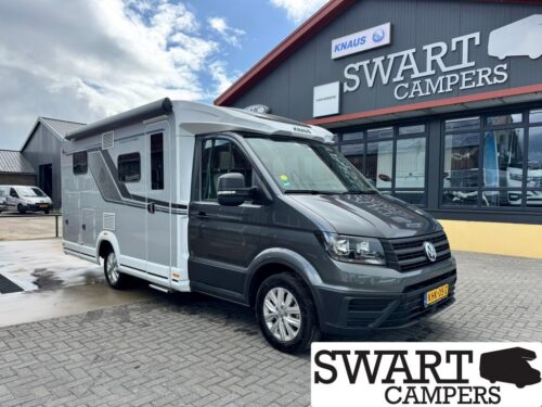 KNAUS VAN TI 640 MEG VANSATION - Swart Campers Grey and white Volkswagen camper van parked outside the Swart Campers showroom, with the building sign visible.
