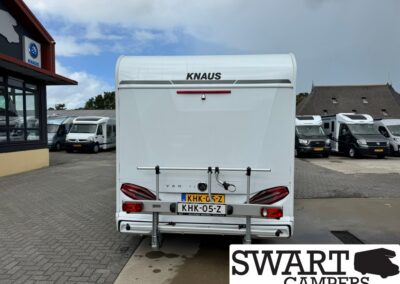 Rear view of a white KNAUS caravan with bicycle rack, license plate KHK-05-Z, at a camper dealership (SWART CAMPERS watermark)
