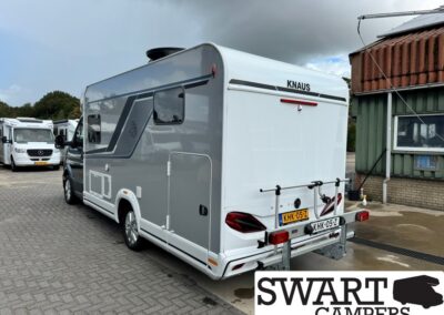 Rear view of a white and gray KNAUS caravan parked in a lot, with SWART CAMPERS watermark.