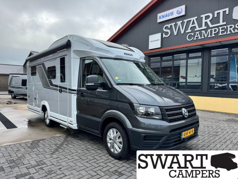 Grey and white KNAUS motorhome parked outside the SWART CAMPERS showroom.