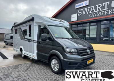 Grey and white KNAUS motorhome parked outside the SWART CAMPERS showroom.
