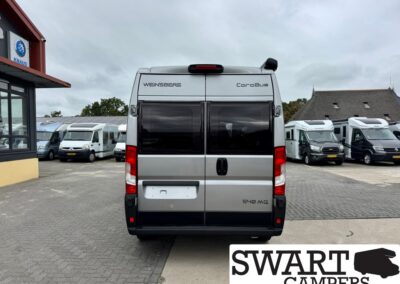 Rear view of a silver Weinsberg CaraBus camper van at a dealership lot, with other motorhomes parked in the background and SWART CAMPERS watermark in the corner.