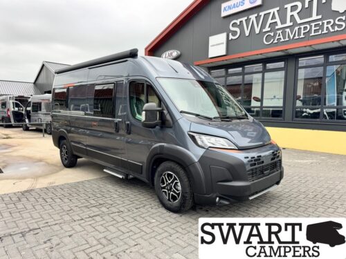Dark gray camper van with raised roof parked in front of a Swart Campers shop storefront.