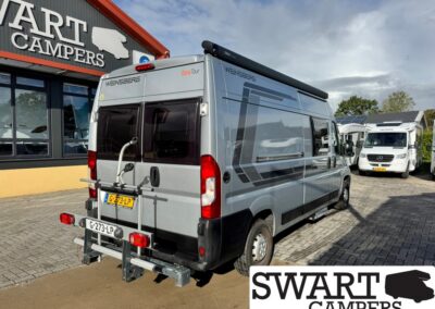 Silver Weinsberg CaraTour camper van with rear bike rack parked outside Swart Campers showroom; another motorhome visible in the lot.