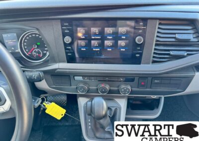 Dashboard view of a vehicle interior showing a central touchscreen, climate controls, and gear shifter (P, R, N, D).