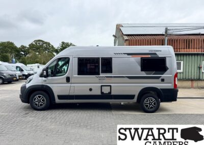 Side view of a silver Weinberg/Weinsberg camper van parked on a lot, with black wheels and decals along the side, SWART CAMPERS watermark in the corner.