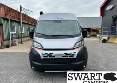 Front view of a light-gray Weinsberg camper van in a paved lot, with a black bumper and orange marker lights.