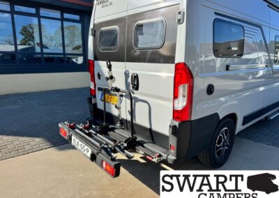 Rear view of a white Knaus BoxLife camper van with a mounted bike rack carrying two bicycles.