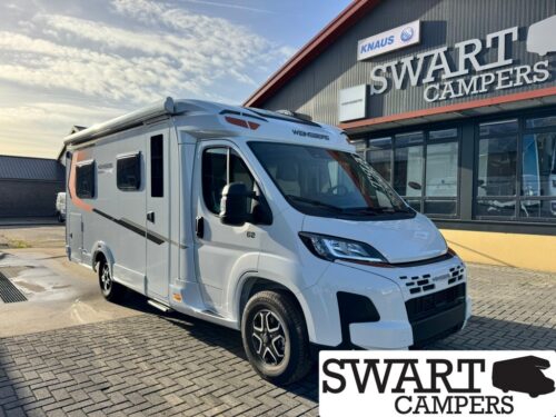 White Weinsberg motorhome parked in front of a Swart Campers dealership building under a blue sky.